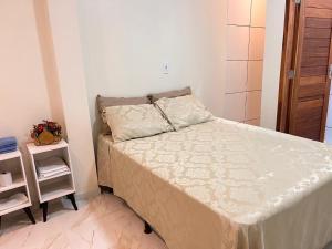 una piccola camera da letto con un letto e un comodino di Flat com quarto e sala a Viçosa do Ceará