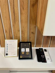 a remote control and a book sitting on a table at Vidolux Studio - Free Garage and Fast WiFi in Niš