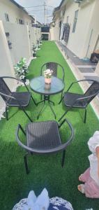 a patio with a table and chairs on the grass at REZEKI MUEZZA 3BR2B Cozy Homestay in Teluk Intan