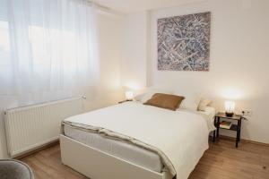 a bedroom with a white bed and a painting on the wall at Vanjkuš in Marija Bistrica