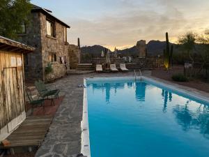 a large blue swimming pool in front of a house at Tucson Mountain Guest Ranch in Tucson