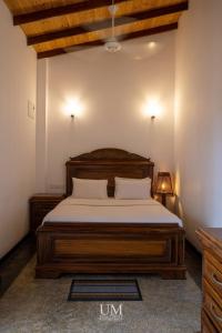 een slaapkamer met een houten bed in een kamer bij Epic Unawatuna in Unawatuna