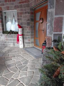 Een sneeuwpop staat buiten een huis. bij Dió vendégház in Praid