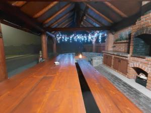 een grote houten tafel in een kamer met een open haard bij Dió vendégház in Praid