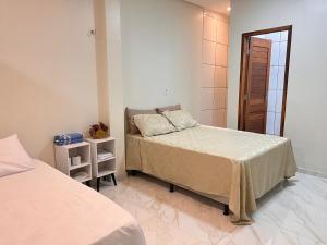 una camera da letto con due letti in una stanza di Flat com quarto e sala a Viçosa do Ceará