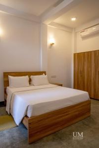 een slaapkamer met een groot bed met witte lakens bij Epic Unawatuna in Unawatuna