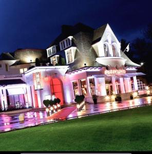 a large white building with red doors at night at La loge Royale in Cucq