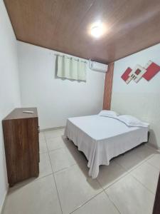 una camera da letto con un letto e un tavolo di Apê da Lili a Ilha de Boipeba