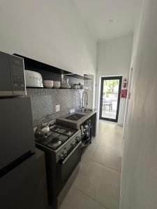 a kitchen with a stove and a sink at White House Cottage in Koekoeb