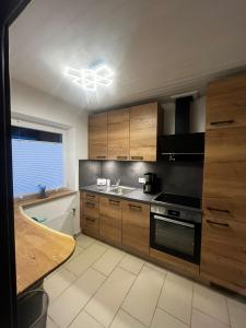 a kitchen with wooden cabinets and a stove top oven at Stylish & Spacious Apartment with Patio in Stams