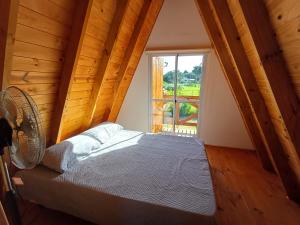a bedroom with a bed with a fan and a window at Cabañas Amapola del 66 in Miramar
