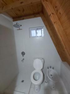a bathroom with a toilet and a sink at Cabañas Amapola del 66 in Miramar +51 photos