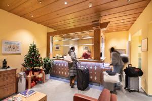 a group of people waiting at a counter in a store at Hotel Grindelwalderhof in Grindelwald