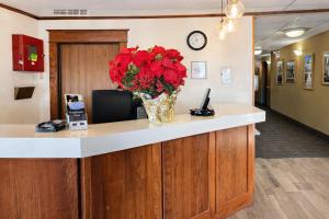 a lobby with a vase of red flowers on a counter at Fireside Inn and Suites in Devils Lake +48 photos