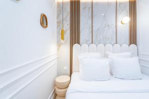 a white bedroom with a white bed with white pillows at Garbo hotel in Paris