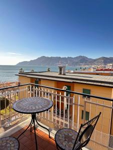 a patio with a table and chairs on a balcony at Sul Mare Apartment - Seafront with Sea View in Salerno