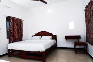 a bedroom with a bed and a chair at Aroma Resort Hill Palace in Kolli Hills