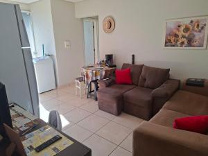 een woonkamer met een bank en een tafel bij Apart próximo a Unimed, Catedral, HSA com 2 Ar e garagem in Santo Ângelo