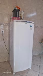 frigorifero bianco in cucina con bancone di Refúgio baiano Ilhéus WI-FI a Ilhéus