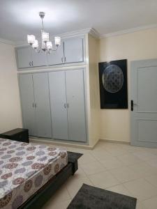 een slaapkamer met een bed en een kroonluchter bij Listing Room Dual in Oulad Yakoub