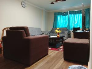 ein Wohnzimmer mit zwei Stühlen und einer Couch in der Unterkunft Central Stay Departamentos III in Oruro