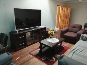 ein Wohnzimmer mit einem Flachbild-TV und einem Couchtisch in der Unterkunft Central Stay Departamentos III in Oruro