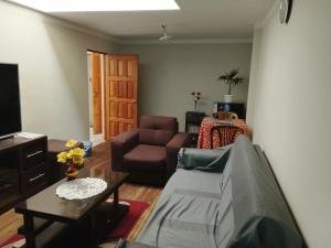 ein Wohnzimmer mit Sofa und Tisch in der Unterkunft Central Stay Departamentos III in Oruro