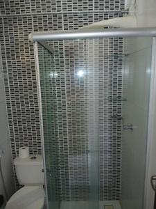 a bathroom with a glass shower with a toilet at Brisa Brasil Residence in Fortaleza