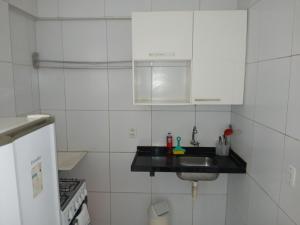 a white kitchen with a sink and a stove at Brisa Brasil Residence in Fortaleza +55 photos