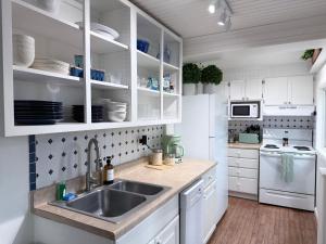 a kitchen with white cabinets and a sink at The Float House at Buckeye Lake - Hot Tub - Patio - Privacy in Thornville
