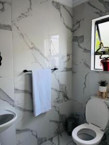 a white bathroom with a toilet and a sink at 4 at Granada 1 in East London