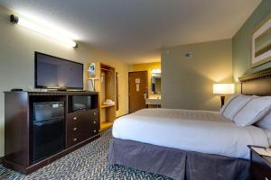 a hotel room with a bed and a flat screen tv at Fireside Inn and Suites in Devils Lake