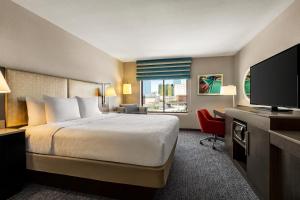een hotelkamer met een bed en een flatscreen-tv bij Hampton Inn Tropicana in Las Vegas