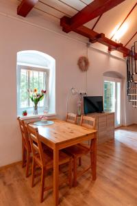 a dining room with a wooden table and chairs at Abi-Lo Vendégház Nagypeterd in Nagypeterd