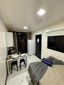 una cucina con un letto e un tavolo con due sedie di Loft 04 na Praia Brava a Itajaí