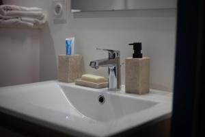a white bathroom sink with a faucet and towels at Au coeur de la Roche in La Roche-sur-Yon +11 photos