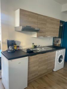 a kitchen with a sink and a washing machine at Au coeur de la Roche in La Roche-sur-Yon