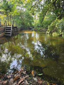a river with a bridge and stairs in the water at RECANTO DO SABIÁ in Carolina