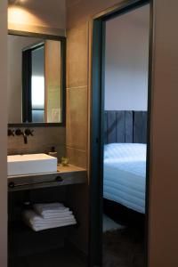 a bathroom with a sink and a bed and a mirror at Trento Hotel Boutique in San Salvador de Jujuy +35 photos