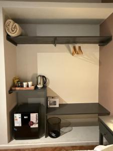 a shelf in a kitchen with a coffee maker and a microwave at Trento Hotel Boutique in San Salvador de Jujuy