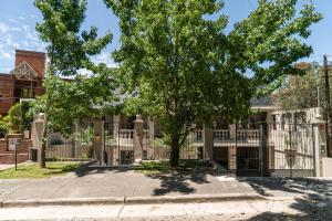 a tree in front of a fence in front of a house at Trento Hotel Boutique in San Salvador de Jujuy