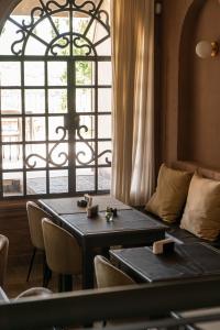 a table and chairs in a room with a window at Trento Hotel Boutique in San Salvador de Jujuy