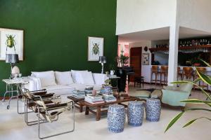 un salon avec un canapé blanc et un mur vert dans l'établissement Pousada Vila Corada, à Pipa