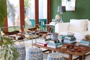 un salon avec une table avec des livres et des chaises dans l'établissement Pousada Vila Corada, à Pipa 141 autres photos