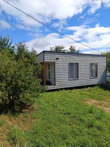 una piccola casa bianca su un prato di Refugio Lemuy - Chiloé a Puqueldón