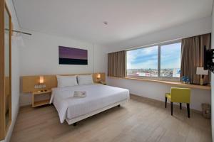 una stanza d'albergo con un letto e una finestra di Whiz Prime Hotel Sudirman Pekanbaru a Pekanbaru Altre 51 foto