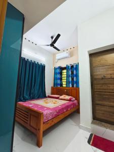 une chambre avec un lit et un ventilateur de plafond dans l'établissement Urban villa, à Trivandrum