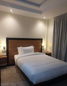 a bedroom with a large bed with a wooden headboard at Hotel redouane in Marrakech