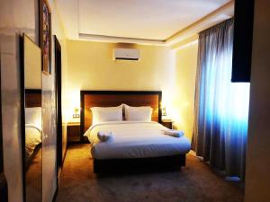 a hotel room with a bed and a window at Hotel redouane in Marrakech +10 photos