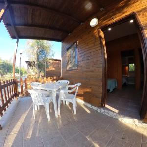 een terras met een witte tafel en twee witte stoelen bij La Carcara in Otranto